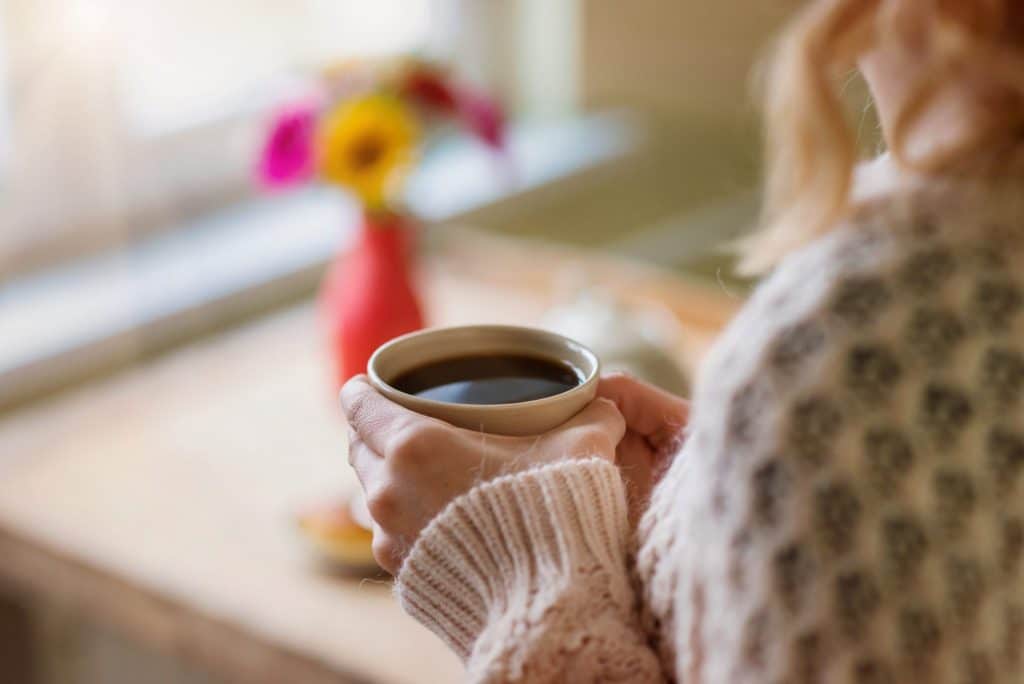Beautiful woman relaxing at home with cup of coffee